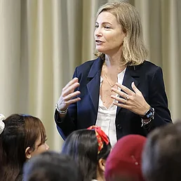 Eine Frau spricht vor einer Gruppe von Menschen.