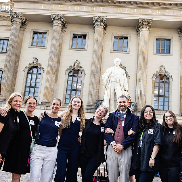 Teamfoto bei der Langen Nacht der Wissenschaften 2024 Eine Gruppe Humboltdianer*innen vor dem HU-Hauptgebäude Arm in Arm in die Kamera schauend