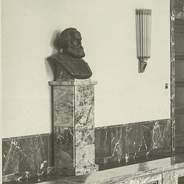 Karl-Marx-Büste Ein elegant eingerichteter Flur mit Marmorverkleidung, einer Marx-Büste und modernen Leuchten.
