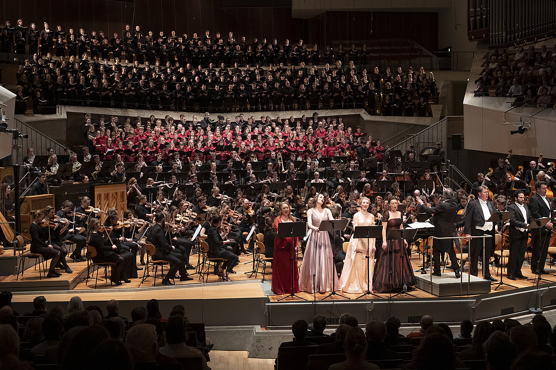 Mahlers 8. Sinfonie im Konzerthaus Berlin Ein gewaltiges Orchester mit Chor und Solosänger*innen in einem Konzerthaus in Berlin. alle sind festlich in Abendrobe gekleidet.