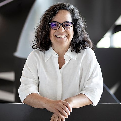 Genombiologin: Ana Pombo Ana Pombo lehnt such auf einen Tisch und lacht in die Kamera