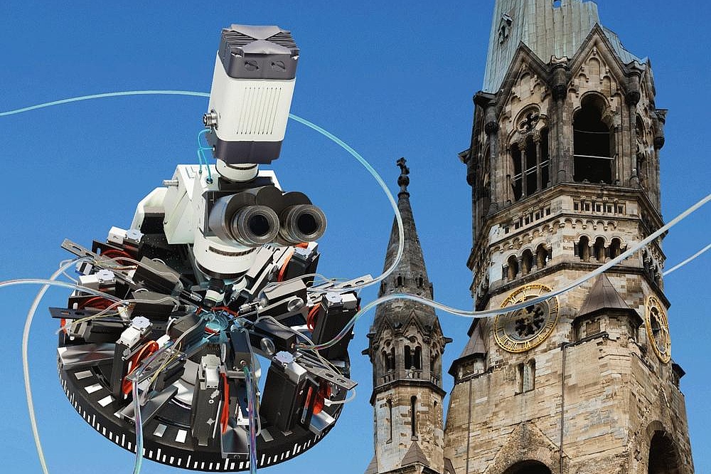 NeuroCure Ein Mikroskop schwebt in der Luft vor der Gedächtniskirche in Berlin
